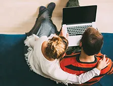 aerial view of woman and man around a laptop