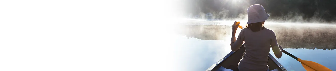 woman wearing a hat rowing a boat