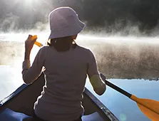woman wearing a hat rowing a boat