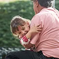 older man holding little girl