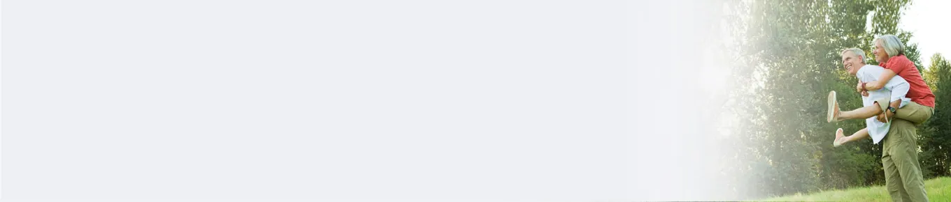 older man holding older woman on his back