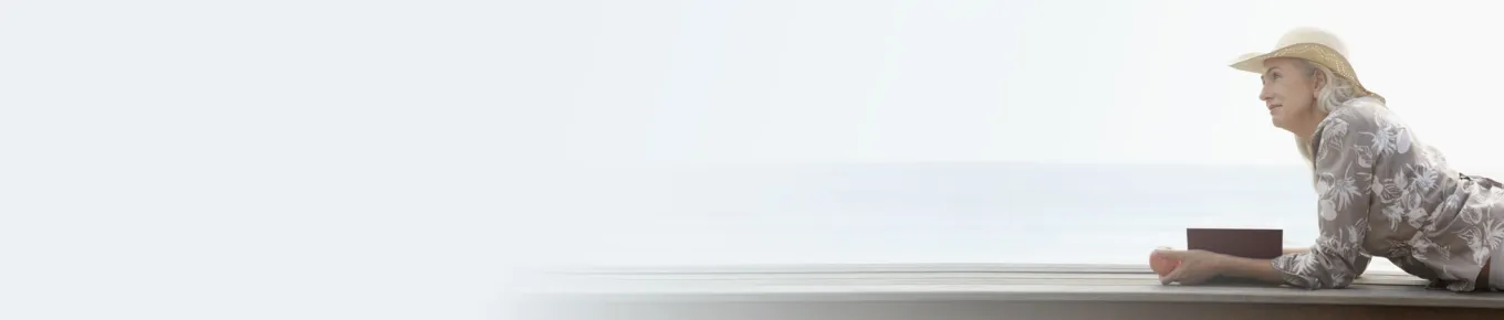 woman laying on a dock wearing a hat