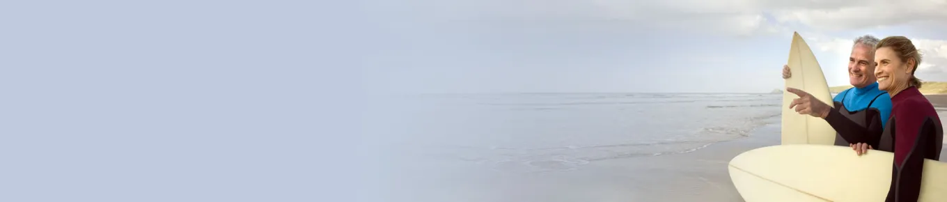 couple holding surf boards on the beach