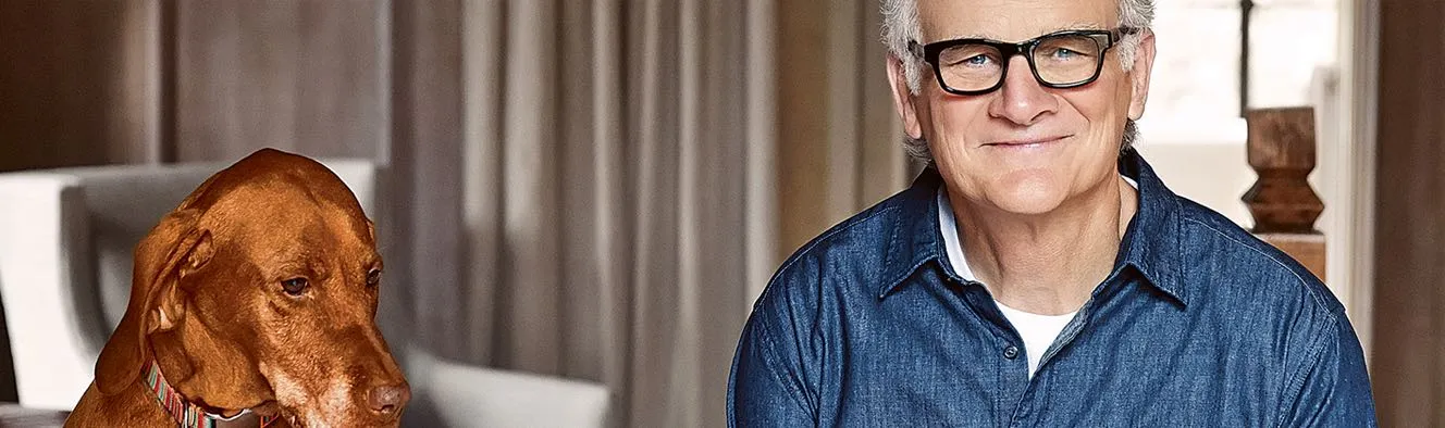 older man wearing glasses with a dog