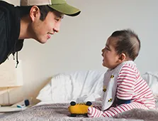 man with hat talking to a baby
