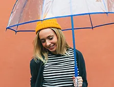 young woman wearing a yellow hat holding an umbrella 