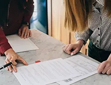 people looking at papers on a desk