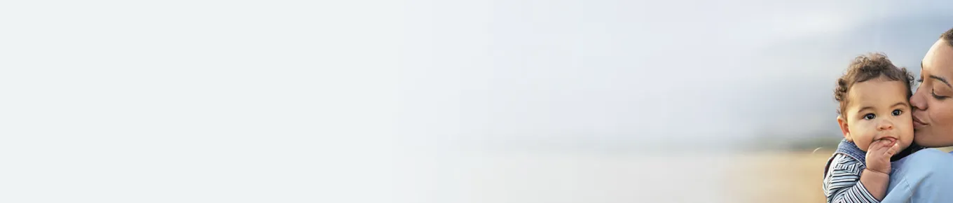 woman kissing baby in her arms